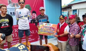 Asisten II Setkab Kukar Wiyono saat membagikan hadiah kepada para pemenang lomba balap ketinting. 